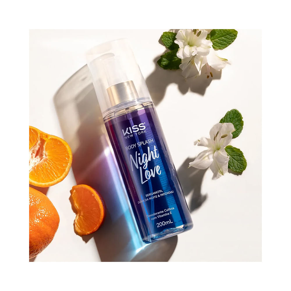 Frasco de Body Splash Kiss New York Night Love 200ml com flores e fatias de laranja ao lado